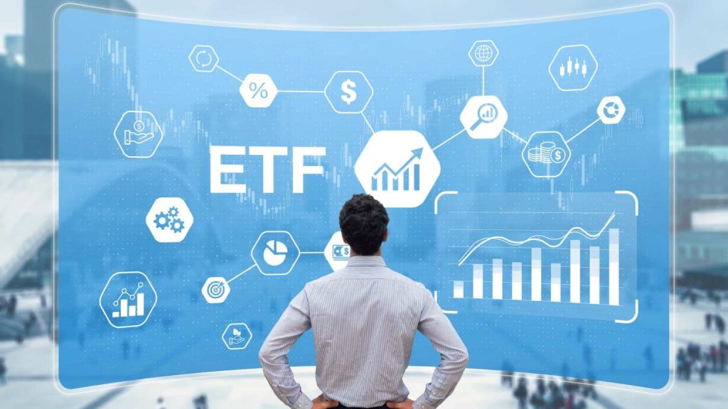 Homem de camisa, em pé, a analisar uma construção digital de elementos relacionados com a bolsa de valores e a palavra ETF em destaque.