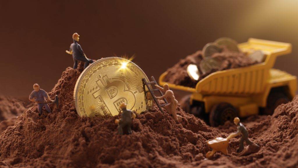 Moedas de bitcoin. Figuras de miniatura a simular a mineração de criptomoedas.