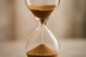 Ampulheta com grãos dourados a cair, simbolizando o passar do tempo e a incerteza sobre o momento ideal para investir.